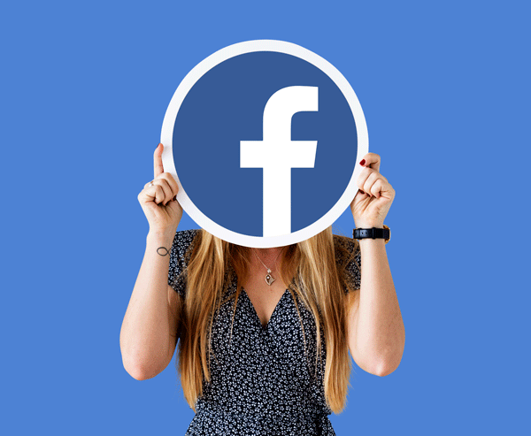 Mujer sostiene cartel de los objetivos de Facebook